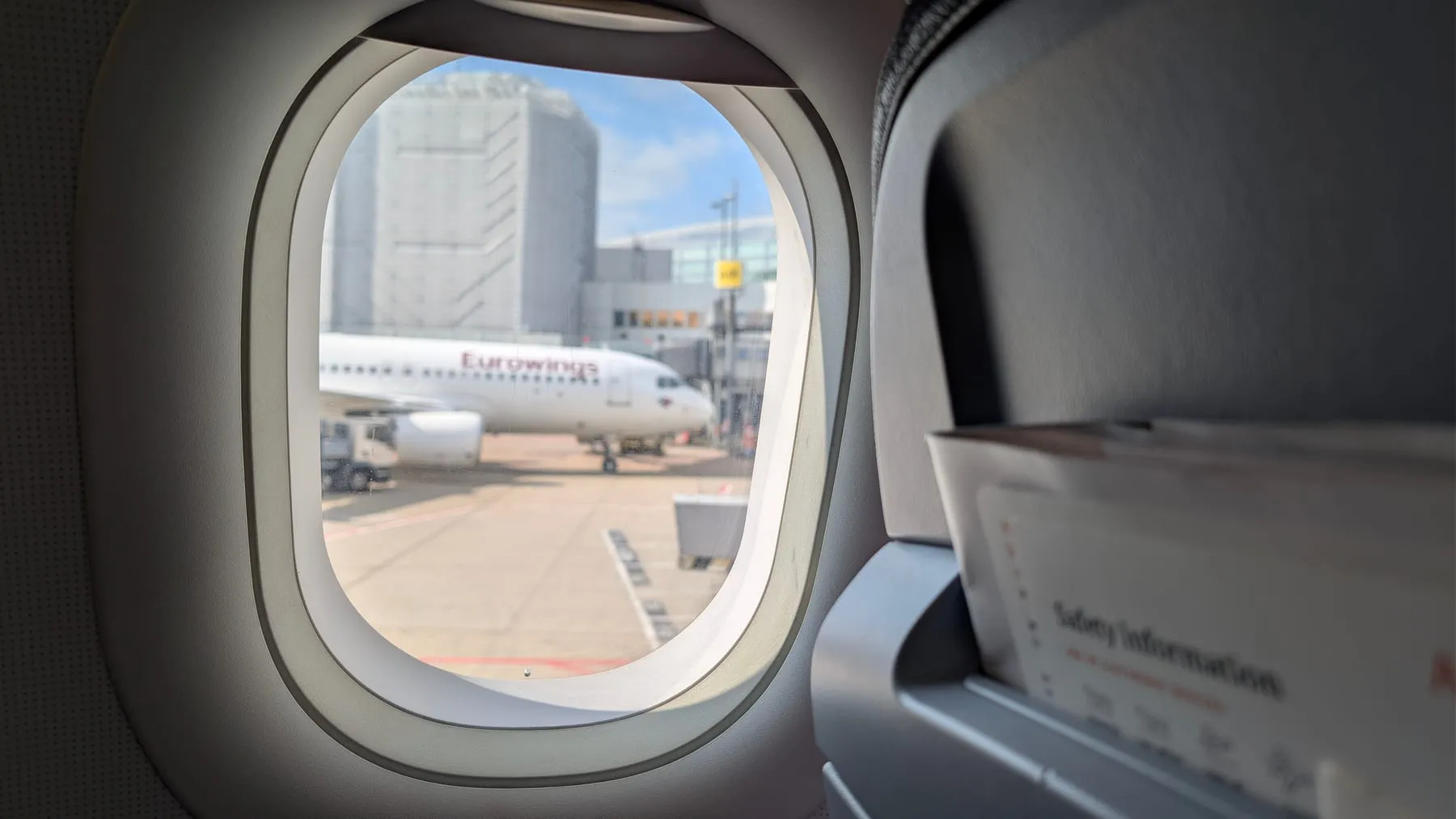 Eurowings aircraft on the apron at Düsseldorf Airport, seen from a plane window — Düsseldorf Airport Transfer (DUS)
