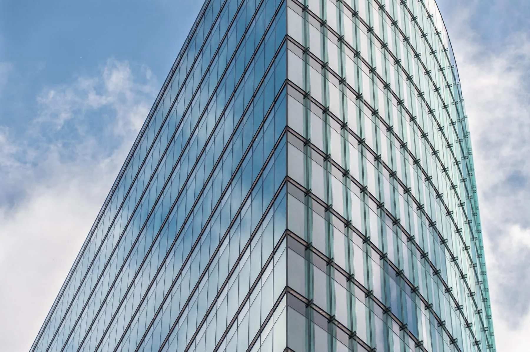 An office tower's glass frontage at street level — Corporate Chauffeur & Airport Transfer Accounts, Frankfurt