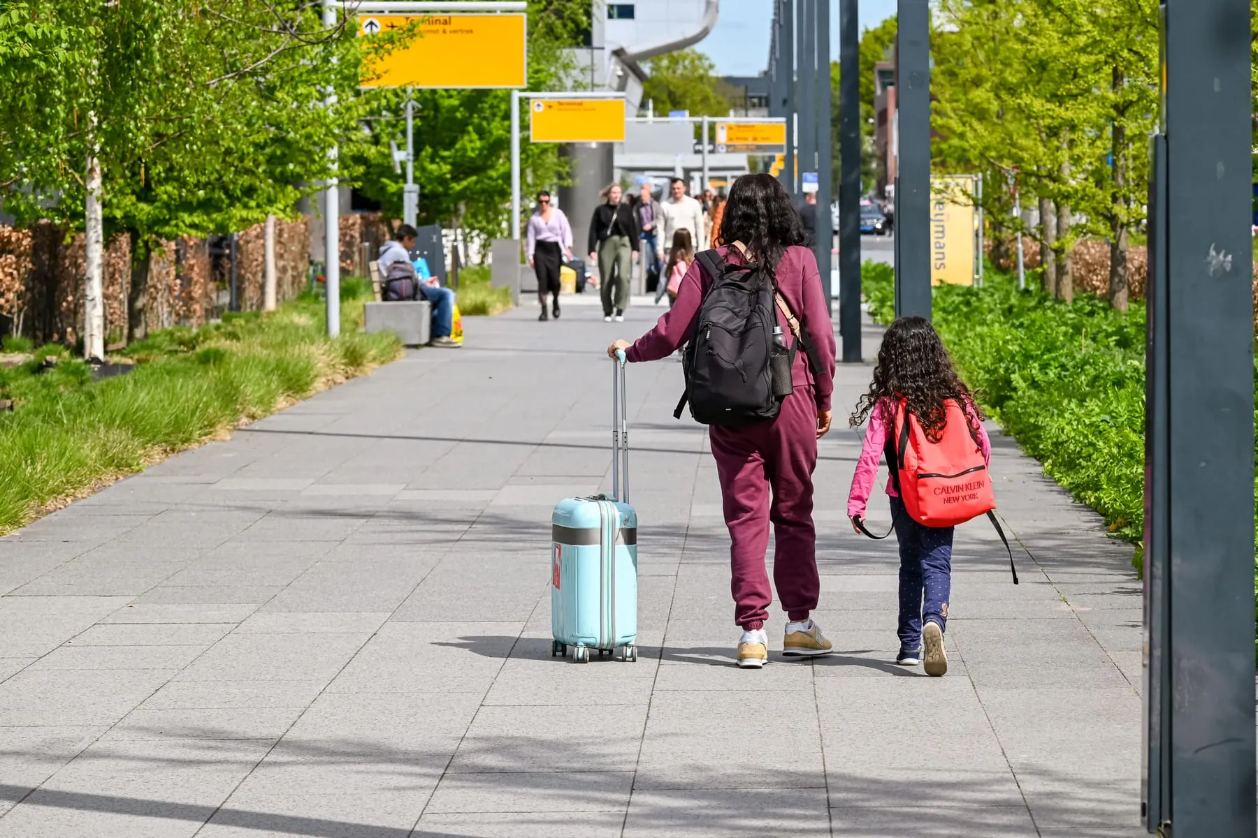 A parent and child walking from the terminal with their luggage — Frankfurt Airport Family Concierge & Travel Assistance
