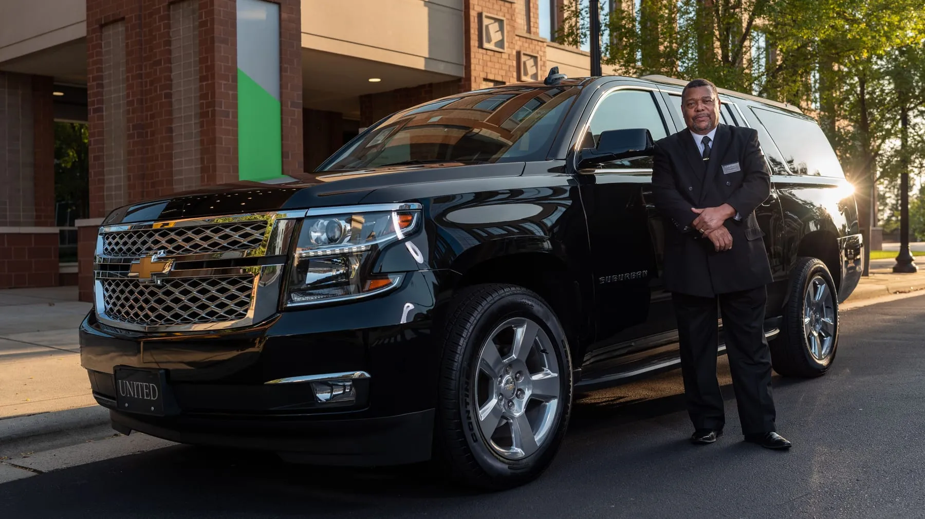 A chauffeur standing beside a car on an open road — Full-Day Chauffeur Service Frankfurt