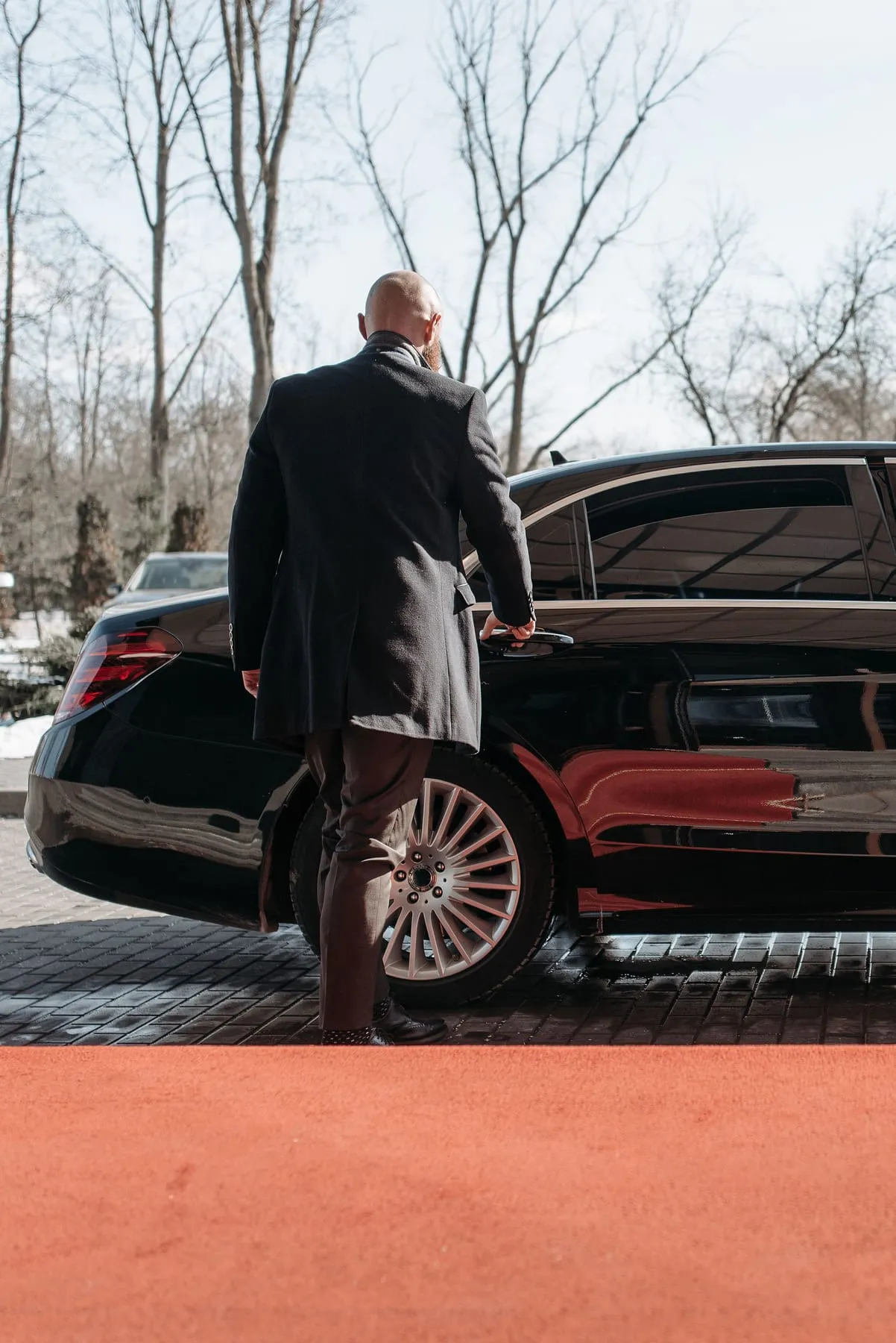 A chauffeur in a dark suit at the open door of a black saloon — Private Chauffeur & Airport Transfers