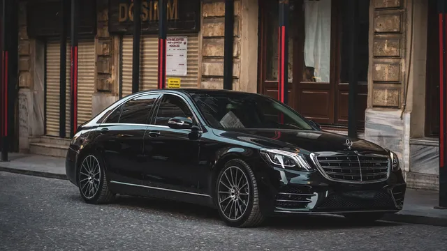 A black saloon parked on a cobbled street in a European city — Hourly Chauffeur Essen – Düsseldorf Airport