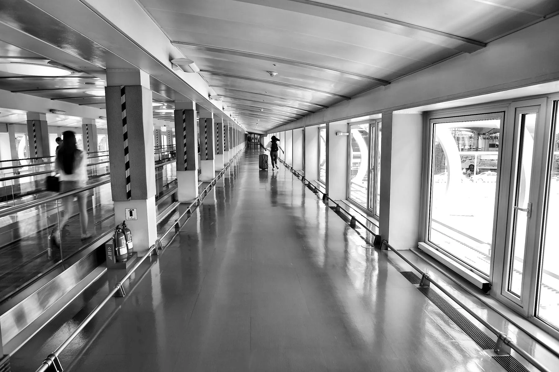 A traveller crossing a wide, empty airport walkway — Frankfurt Airport Transit Concierge Service